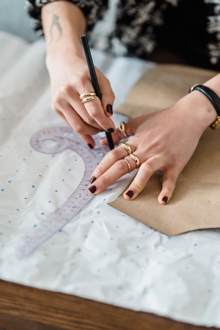 Mastering the First Impression: Your intriguing post title goes here High angle of crop anonymous female dressmaker tracing with pencil on paper with carton template and curved ruler in workspace
